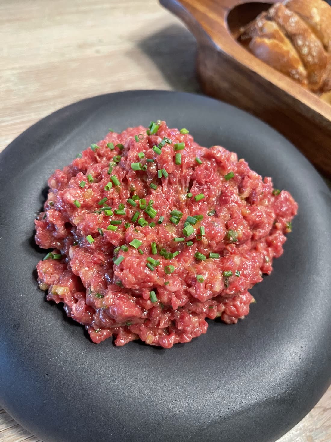 Tartar de vită pe farfurie neagră